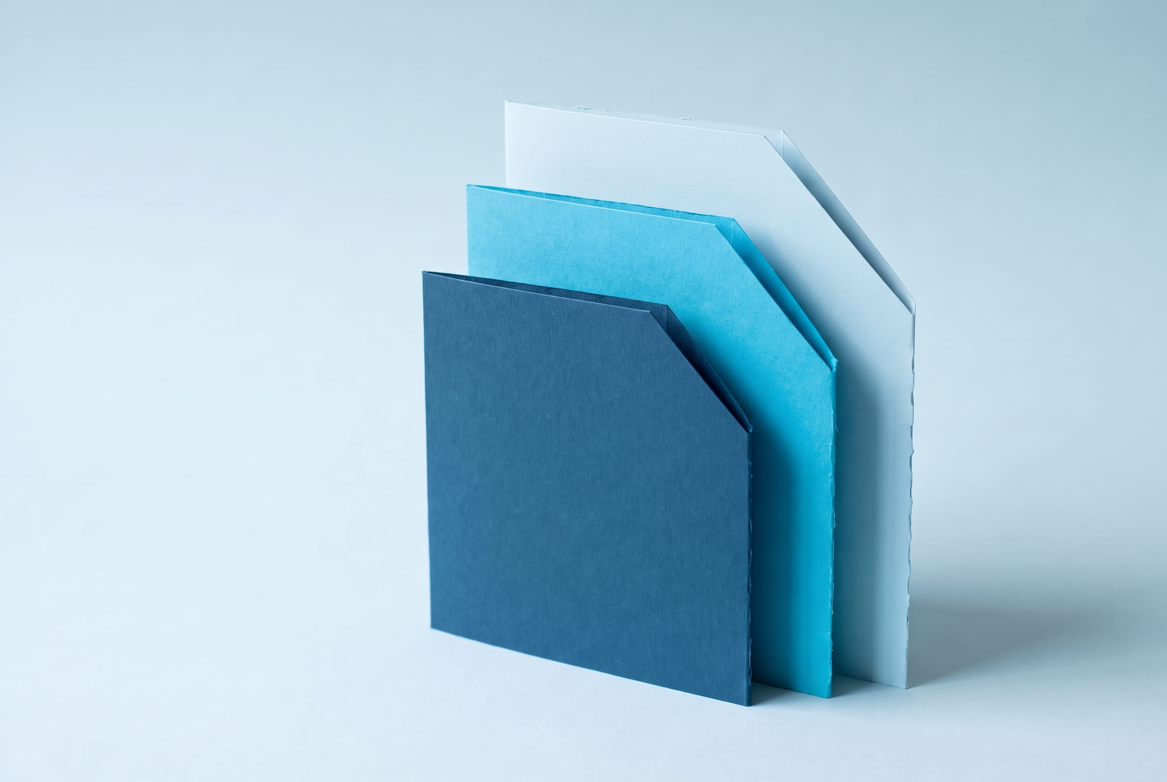 Cyaan kartonnen panelen achter elkaar gezet met verspringing, elk met een afgesneden hoek